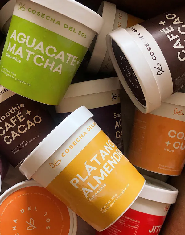 Empaques de Aguacate + Matcha, Café + Cacao y Plátano + Almendra, amontonados.