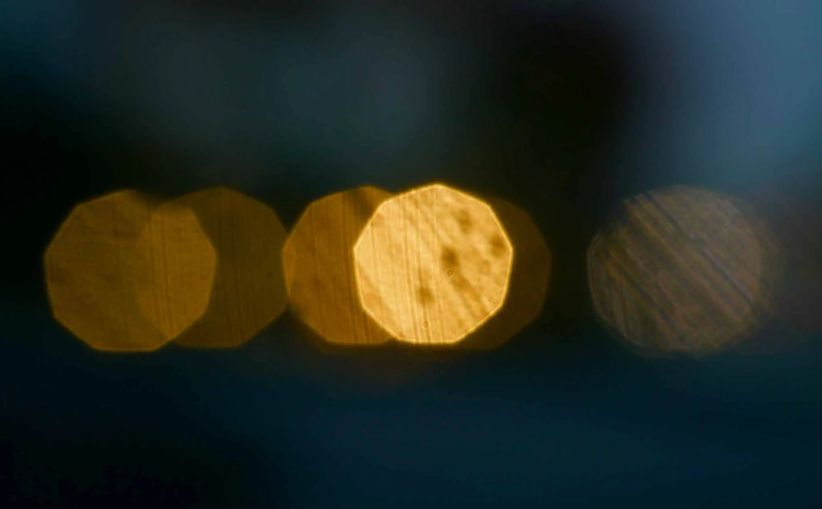 Luces ámbar desenfocadas en una hilera, sobre un fondo azul oscuro.