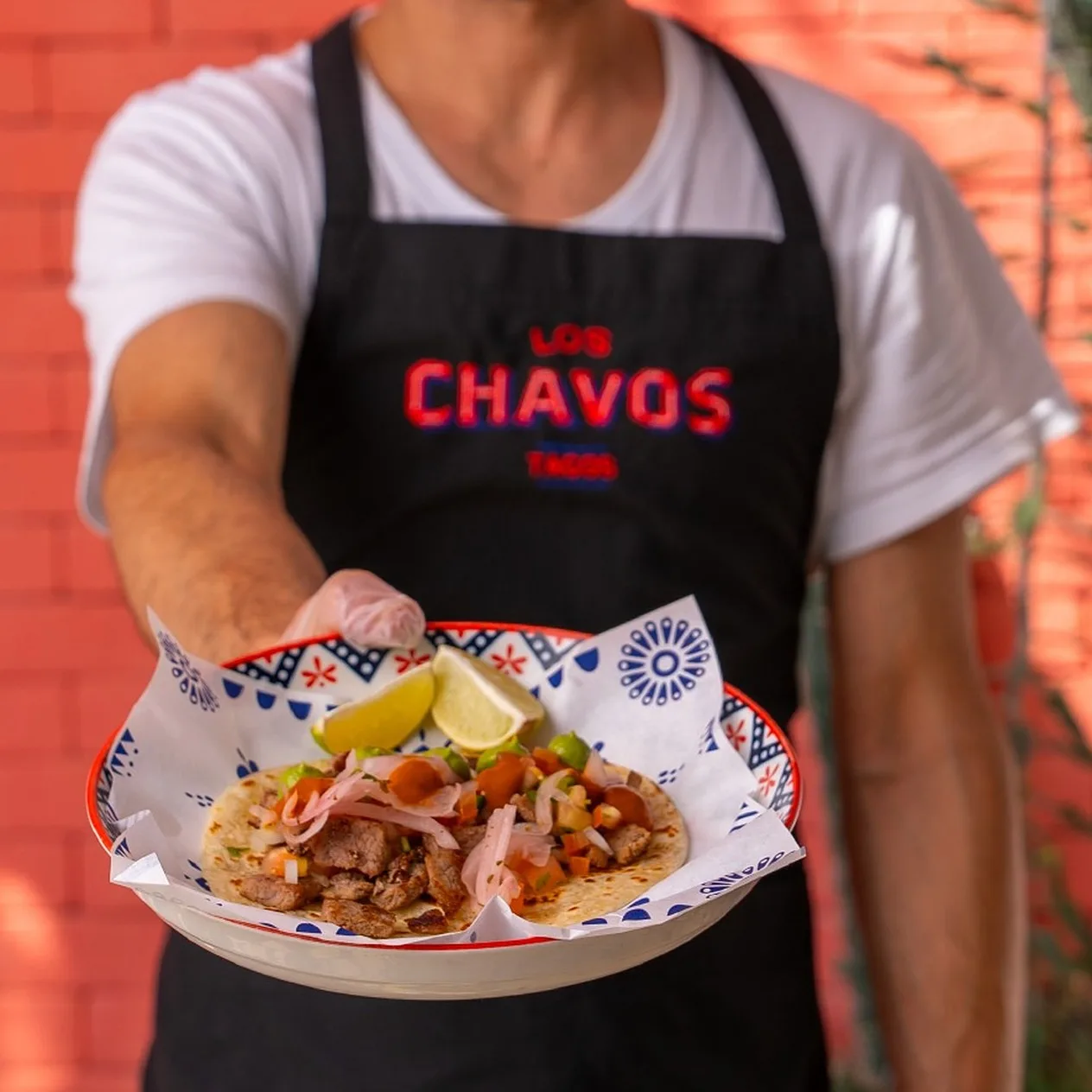 Mandil negro con el logotipo de Los Chavos en rojo.