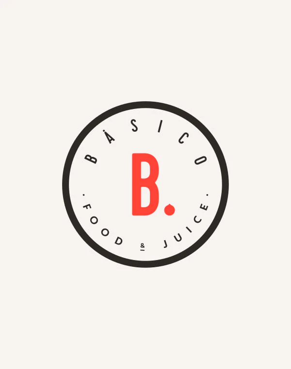 Logotipo secundario de Básico: un sello redondo con BÁSICO y «FOOD & JUICE» alrededor de la B. roja.